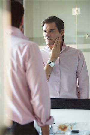 Man scrutinizing himself in mirror Photographie de stock - Premium Libres de Droits, Code: 632-08545845