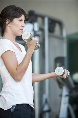 simsearch:632-08545978,k - Woman lifting weights in gym Stock Photo - Premium Royalty-Free, Code: 632-08545893