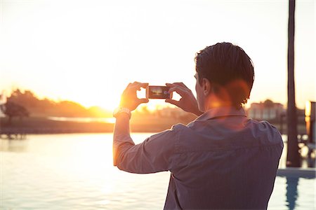 photos of man backside - Man photographing sunset with smartphone Stock Photo - Premium Royalty-Free, Code: 632-08545900