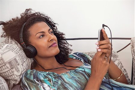 simsearch:632-07674516,k - Woman relaxing to tunes playing on smartphone Photographie de stock - Premium Libres de Droits, Code: 632-08545932