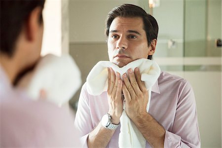 secar - Man looking in mirror, drying his face with a towel Photographie de stock - Premium Libres de Droits, Code: 632-08545968