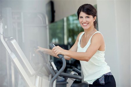 simsearch:632-08545978,k - Woman exercising in fitness club, smiling cheerfully Stock Photo - Premium Royalty-Free, Code: 632-08545974