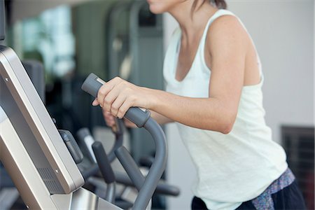 simsearch:632-08545978,k - Woman using exercise machine in fitness club, cropped Stock Photo - Premium Royalty-Free, Code: 632-08545973