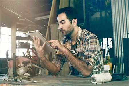 Man in workshop using digital tablet to access do-it-yourself repair instructions on internet Foto de stock - Sin royalties Premium, Código: 632-08698324