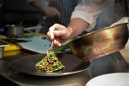 Chef spooning lentil dish onto serving plate Photographie de stock - Premium Libres de Droits, Code: 632-08698594