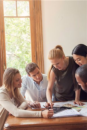 simsearch:632-08886441,k - Colleagues looking at digital tablet together in office Stock Photo - Premium Royalty-Free, Code: 632-08886440