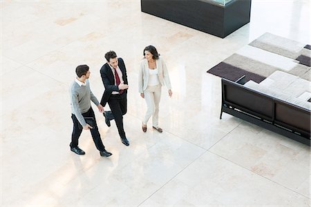 Business associates walking together in office lobby Foto de stock - Sin royalties Premium, Código: 632-08886601