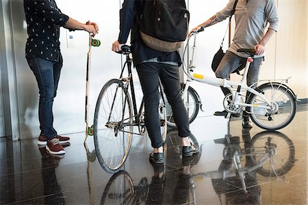 Men waiting for elevator with bicycles and longboard, low section Stock Photo - Premium Royalty-Free, Code: 632-08886618