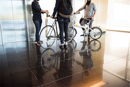 Men waiting for elevator with bicycles and longboard, low section Stock Photo - Premium Royalty-Free, Code: 632-08886619