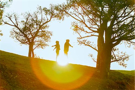Couple enjoying nature, backlit by sunlight Stock Photo - Premium Royalty-Free, Code: 632-08886762