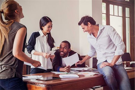 simsearch:632-08886369,k - Colleagues laughing together while collaborating on project Photographie de stock - Premium Libres de Droits, Code: 632-08886929