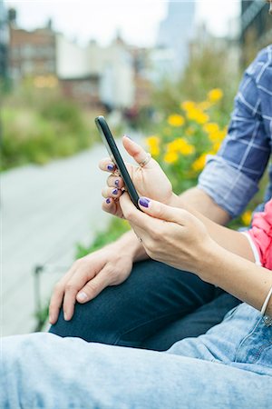 Couple using smartphone outdoors, cropped Stock Photo - Premium Royalty-Free, Code: 632-08887094