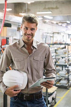 simsearch:632-08993642,k - Factory worker holding hard hat and digital tablet, portrait Foto de stock - Sin royalties Premium, Código: 632-08993438