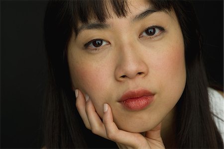 simsearch:632-09140314,k - Young woman with hand under chin, close-up portrait Stock Photo - Premium Royalty-Free, Code: 632-08993455