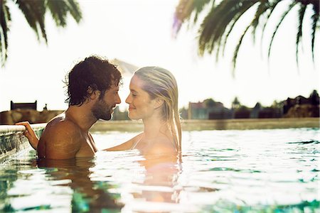 simsearch:632-08129776,k - Couple relaxing together in resort swimming pool Stock Photo - Premium Royalty-Free, Code: 632-08993460