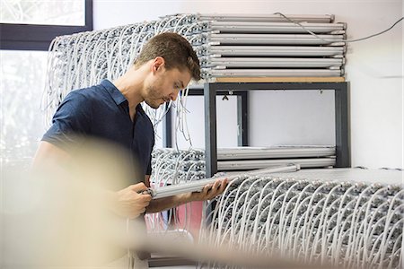 electronics manufacturing - Man inspecting light bulbs in factory Stock Photo - Premium Royalty-Free, Code: 632-08993579