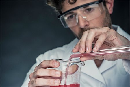 simsearch:632-03516577,k - Scientist pouring liquid from test tube into beaker Stock Photo - Premium Royalty-Free, Code: 632-08993622