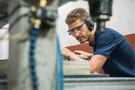 protector de oídos - Machinist working in factory Foto de stock - Sin royalties Premium, Código: 632-08993649