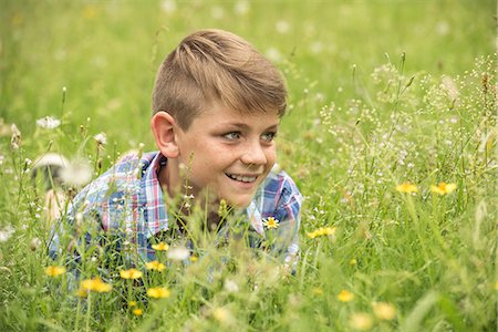 portrait, head and shoulders - Boy lying in meadow, smiling cheerfully Stock Photo - Premium Royalty-Free, Code: 632-09021497