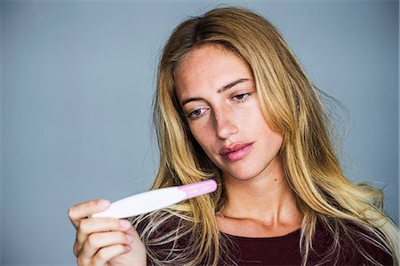 front view of pregnant women - Young woman looking at pregnancy test with disappointed expression Stock Photo - Premium Royalty-Free, Code: 632-09021570