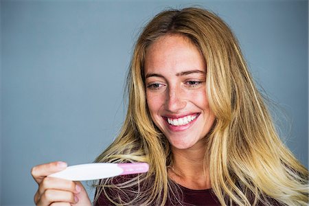 Young woman smiling pregnancy test results Stock Photo - Premium Royalty-Free, Code: 632-09021571