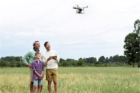 digital tablet and young adult laughing - Multi-generation family playing with drone Stock Photo - Premium Royalty-Free, Code: 632-09021572