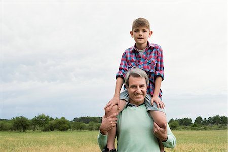 eye contact man portrait - Grandfather carrying grandson on shoulders outdoors Stock Photo - Premium Royalty-Free, Code: 632-09021593