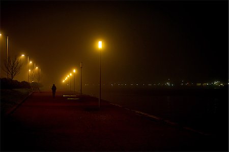 street light at night - Person walking along deserted waterfront at night Stock Photo - Premium Royalty-Free, Code: 632-09039852