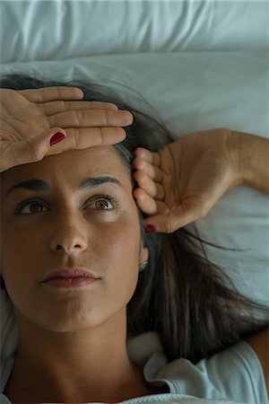 simsearch:632-08698341,k - Woman lying in bed with hand on forehead Foto de stock - Sin royalties Premium, Código: 632-09039896