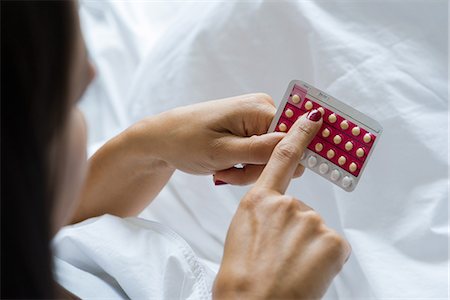 pilule contraceptive - Woman holding birth control pills Photographie de stock - Premium Libres de Droits, Code: 632-09039903