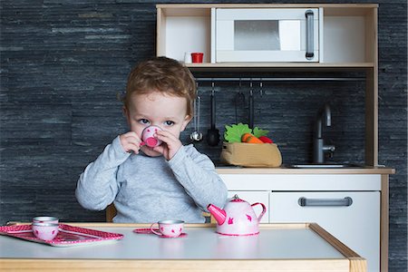 Little girl playing with toy tea set Stock Photo - Premium Royalty-Free, Code: 632-09039941