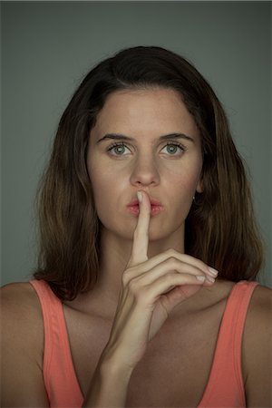 simsearch:632-08886875,k - Young woman holding finger against lips in silence, portrait Foto de stock - Sin royalties Premium, Código: 632-09039955