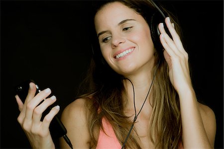 simsearch:632-09021472,k - Young woman using smartphone and listening to headphones Stock Photo - Premium Royalty-Free, Code: 632-09039970