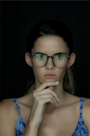 simsearch:632-07539867,k - Young woman wearing glasses, deep in thought, portrait Photographie de stock - Premium Libres de Droits, Code: 632-09039971