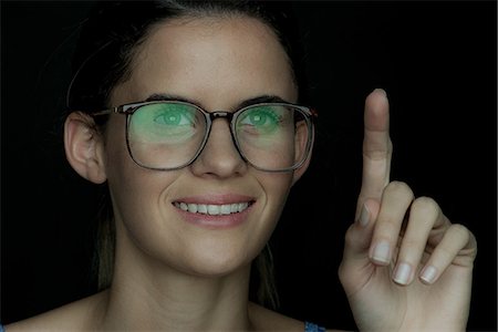 simsearch:632-09021472,k - Young woman smiling with finger raised, portrait Stock Photo - Premium Royalty-Free, Code: 632-09039973