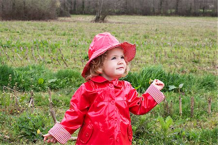 simsearch:633-02417965,k - Little girl wearing rain gear playing in field Fotografie stock - Premium Royalty-Free, Codice: 632-09040106