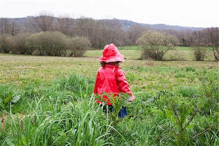 simsearch:633-02417965,k - Little girl wearing rain gear playing in field Fotografie stock - Premium Royalty-Free, Codice: 632-09040111