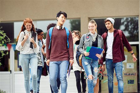 friends smiling together - College students chatting while walking on campus between classes Stock Photo - Premium Royalty-Free, Code: 632-09157947