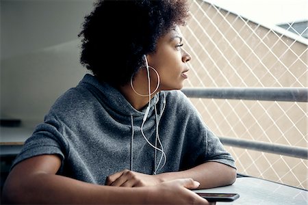 simsearch:649-09078072,k - Young woman listening to earphones and gazing out window Photographie de stock - Premium Libres de Droits, Code: 632-09158138