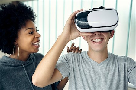 Young man using virtual reality simulator with friend Stock Photo - Premium Royalty-Free, Code: 632-09158153