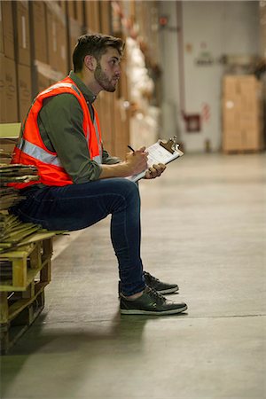 simsearch:632-01157373,k - Worker writing on clipboard in warehouse Fotografie stock - Premium Royalty-Free, Codice: 632-09162785
