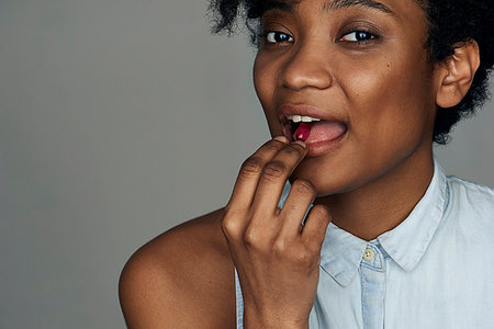 Close-up of young woman taking a pill Stock Photo - Premium Royalty-Free, Code: 632-09192294