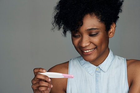 simsearch:632-09192292,k - Close-up of young woman looking at pregnancy test strip Fotografie stock - Premium Royalty-Free, Codice: 632-09192293