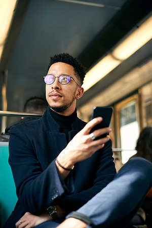 people sitting in a train - Thoughtful businessman holding smartphone Stock Photo - Premium Royalty-Free, Code: 632-09192311