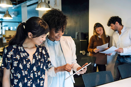 Smiling businesswomen using digital tablet in office Photographie de stock - Premium Libres de Droits, Code: 632-09254605