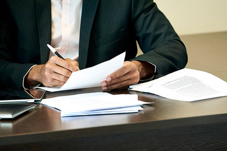 simsearch:632-08227744,k - Businessman checking a document on his desk Stock Photo - Premium Royalty-Free, Code: 632-09254714