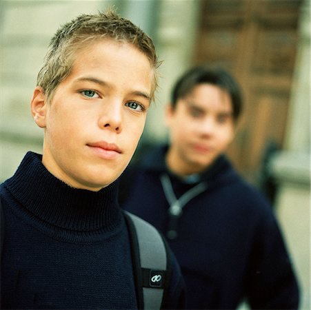 Teenage boy looking into camera, second teenager in background Stock Photo - Premium Royalty-Free, Code: 632-01137067