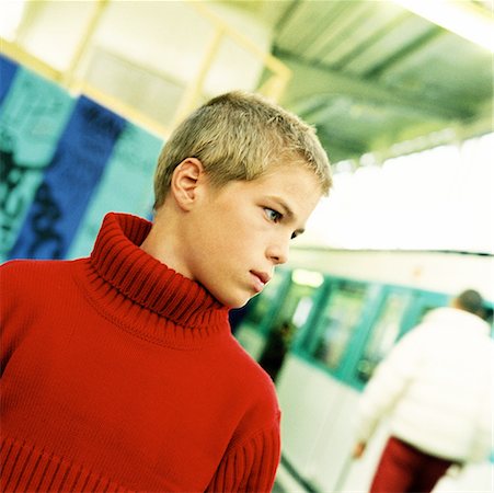 simsearch:695-03382580,k - Teenage boy standing, head and shoulders, with subway train in background Fotografie stock - Premium Royalty-Free, Codice: 632-01137784