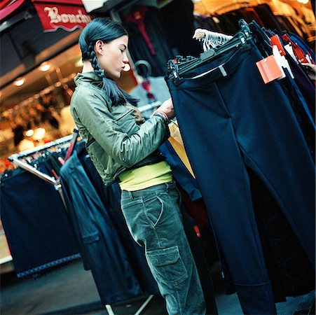 Teenage girl looking at racks of clothing, outside Stock Photo - Premium Royalty-Free, Code: 632-01137828