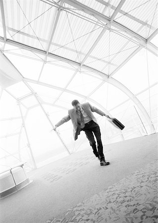 Businessman dancing with briefcase in hand, b&w. Stock Photo - Premium Royalty-Free, Code: 632-01138187